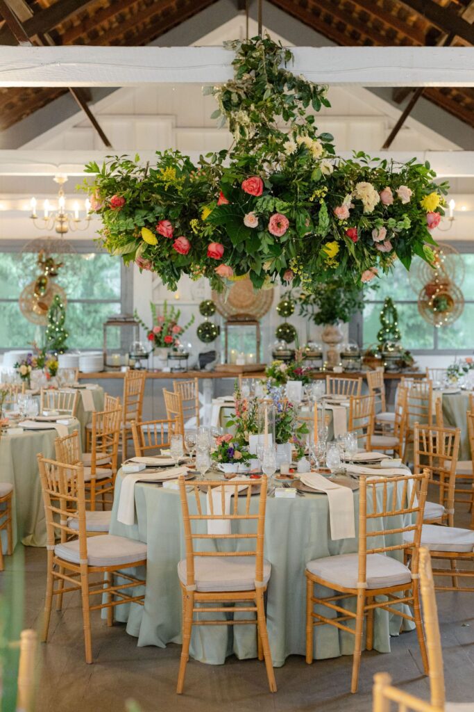 Elegant wedding reception with round tables, light green tablecloths, wooden chairs, and floral centerpieces—an ideal setting reminiscent of the best rehearsal dinner venues Atlanta has to offer.